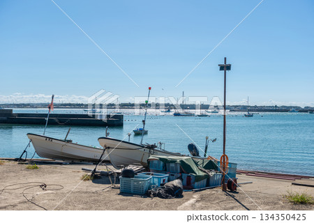 一艘小漁船停靠在港口,展現出一幅平靜的海景。 一艘小漁船停靠在港口,展現出一幅平靜的海景。 134350425