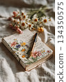 Planning journal with handwritten notes and flowers on table 134350575