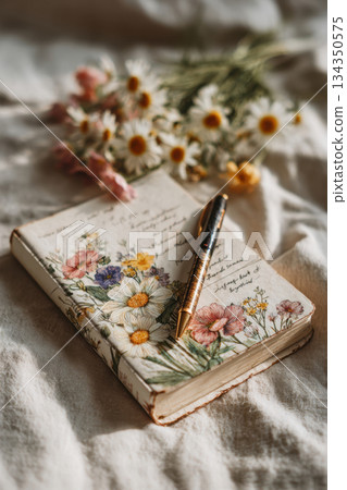 Planning journal with handwritten notes and flowers on table Planning journal with handwritten notes and flowers on table 134350575