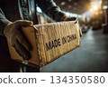 Hands holding cardboard box labeled Made in China in warehouse 134350580