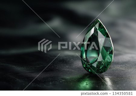 Emerald gemstone on black reflective surface Emerald gemstone on black reflective surface 134350581