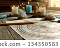 Astrology natal chart with candles and crystals on wooden table 134350583