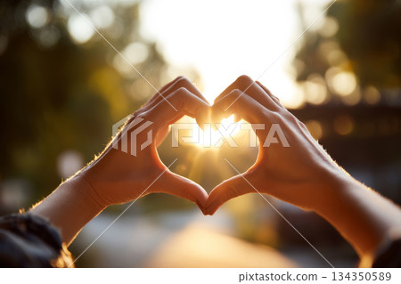 Hands forming heart shape with sunlight in background Hands forming heart shape with sunlight in background 134350589