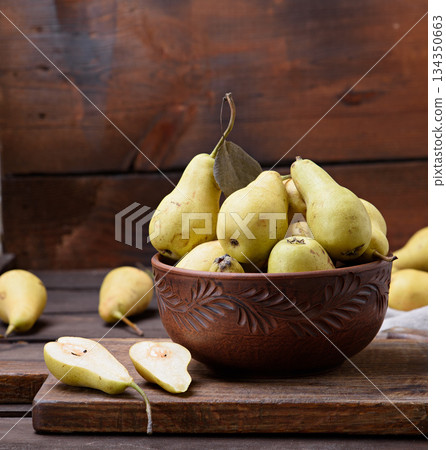 Ripe yellow green pears in a brown ceramic bowl on a wooden table Ripe yellow green pears in a brown ceramic bowl on a wooden table 134350663