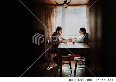 Portrait of poor mature couple sitting at table, fearing the future. Portrait of poor mature couple sitting at table, fearing the future. 134352135