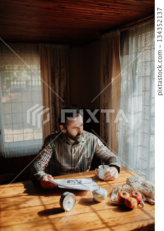Portrait of poor despaired man sitting at table having breakfast. Portrait of poor despaired man sitting at table having breakfast. 134352137