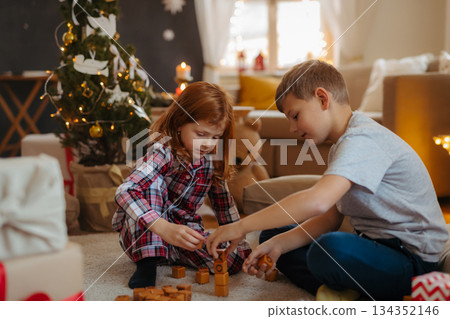 Kids playing with wooden blocks at Christmas. Kids playing with wooden blocks at Christmas. 134352146