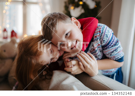 Small girl and boy in pajamas indoors at home at Christmas, playing. Small girl and boy in pajamas indoors at home at Christmas, playing. 134352148
