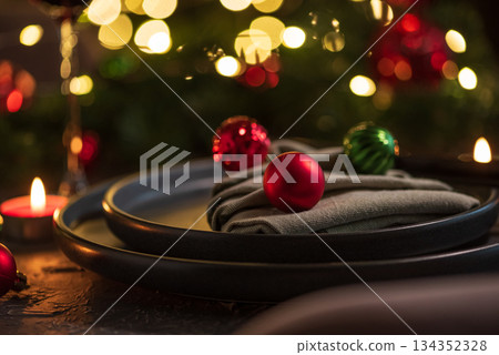 Christmas Table Setting with Tree-Shaped Napkin and Tealight Candles against Christmas lights 134352328