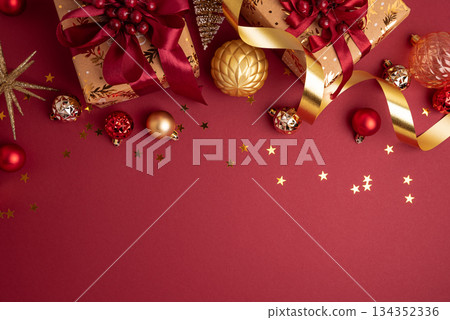 Gold Wrapped Christmas Gifts with Red Ribbons and Ornaments on Red Background Gold Wrapped Christmas Gifts with Red Ribbons and Ornaments on Red Background 134352336