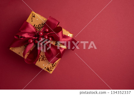 Gold Wrapped Christmas Gifts with Red Ribbons on Red Background 134352337