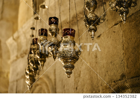 Intricate Antique Orthodox Oil Lamps Hanging in Stone Church 134352382