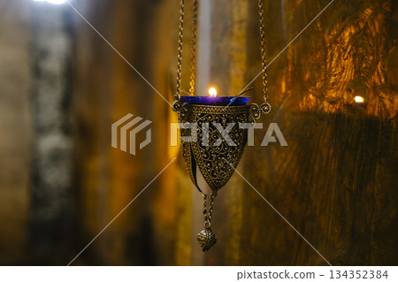 Intricate Antique Orthodox Oil Lamps Hanging in Stone Church 134352384