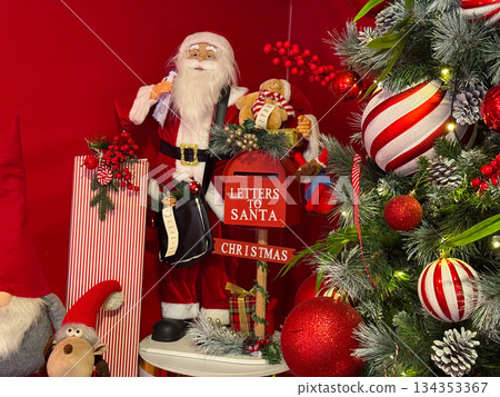 Santa Claus figure with letters to Santa mailbox and gifts. Christmas tradition, festive storytelling and joyful holiday decoration. Santa Claus figure with letters to Santa mailbox and gifts. Christmas tradition, festive storytelling and joyful holiday decoration. 134353367