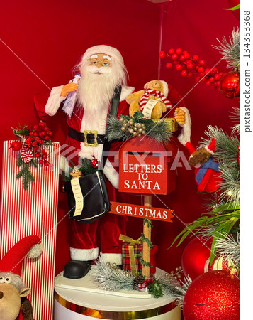 Santa Claus figure with letters to Santa mailbox and gifts. Christmas tradition, festive storytelling and joyful holiday decoration. Santa Claus figure with letters to Santa mailbox and gifts. Christmas tradition, festive storytelling and joyful holiday decoration. 134353368