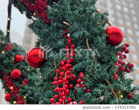 Close-up of Christmas tree branch with red berries and ornaments. Festive seasonal decor, winter celebration and traditional holiday styling. Close-up of Christmas tree branch with red berries and ornaments. Festive seasonal decor, winter celebration and traditional holiday styling. 134353700
