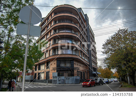 Modern curved building on a city street corner. Curved, modern building on a city street corner with seven stories. 134353788