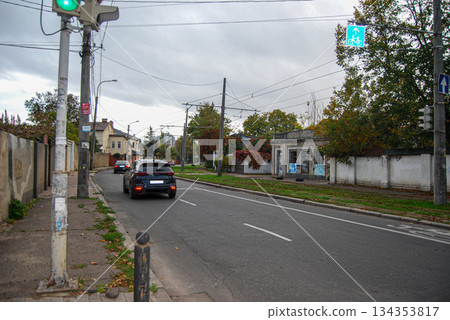 Street view with cars and traffic lights on an overcast day. Urban street scene on an overcast day with several cars on a two-lane road.  134353817