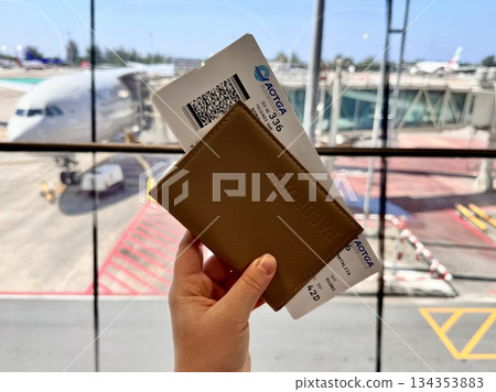 Leather-covered passport and boarding pass on the background of airplanes at Phuket airport Leather-covered passport and boarding pass on the background of airplanes at Phuket airport 134353883