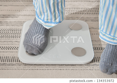 Feet on scale checking health for new year resolution 134353972