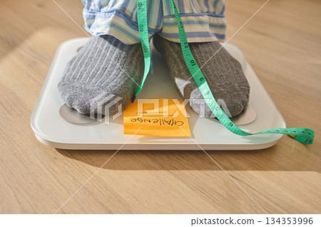 Feet standing on scale measuring weight for challenge Feet standing on scale measuring weight for challenge 134353996