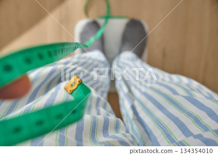 Person measuring weight and waist for new year resolutions 134354010