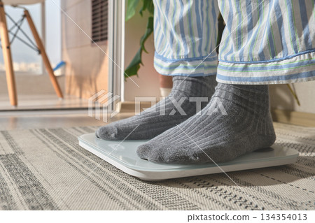 Person checking weight on scale for new year resolution Person checking weight on scale for new year resolution 134354013