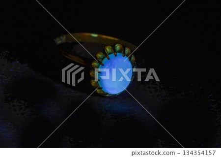 黑色背景上閃亮的藍色戒指 134354157