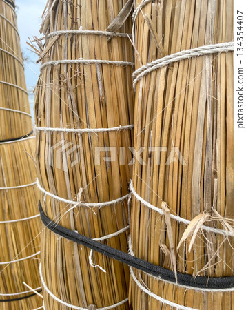 Three tall bamboo poles with strings tied to them 134354407
