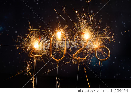 Sparkling New Year 2026. Glowing sparklers forming the number 2026 against a starry night sky Sparkling New Year 2026. Glowing sparklers forming the number 2026 against a starry night sky 134354494