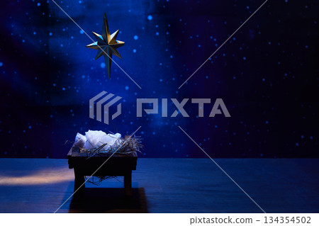 Starry Night Nativity. A nativity scene under a glowing star in a deep blue, starry background 134354502