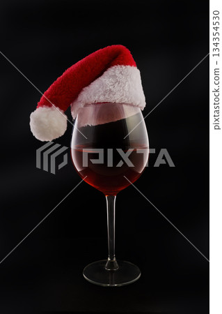 Festive Red Wine. A glass of red wine wearing a Santa hat Festive Red Wine. A glass of red wine wearing a Santa hat 134354530