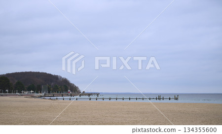 Calm seaside landscape under cloudy sky with minimal human activity Calm seaside landscape under cloudy sky with minimal human activity 134355600