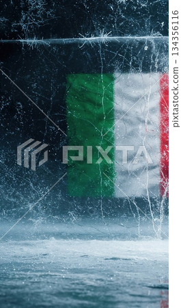 An Italian flag, featuring vibrant green, white, and red stripes, is visible through a heavily cracked and frosted block of ice, creating a stark, cold visual. 134356116