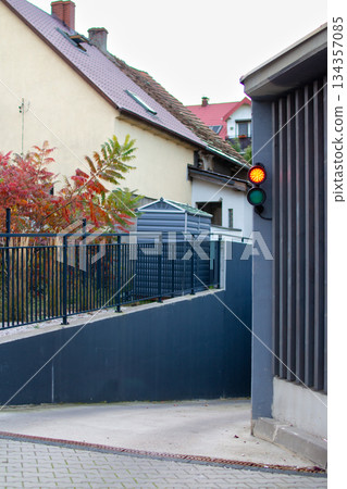 Bright traffic light signals caution near the curved entrance of a small alley Bright traffic light signals caution near the curved entrance of a small alley 134357085