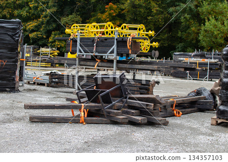 Construction materials stacked in a storage area amid trees during autumn  134357103