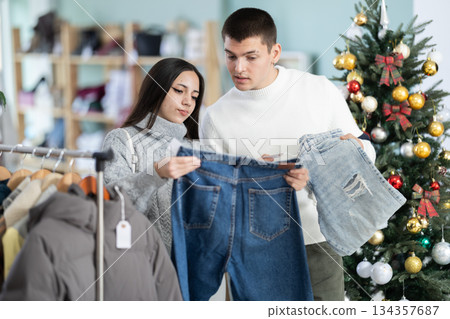 Young couple choosing jeans in store 134357687