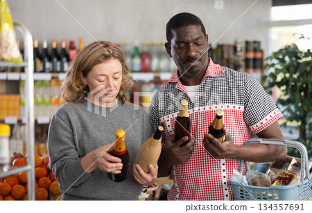 Married couple choose wine and beer together for a holiday party at grocery store 134357691