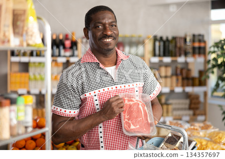 African man choose raw beef entrecote meat for roasting in store African man choose raw beef entrecote meat for roasting in store 134357697