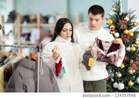 couple chooses underwear against the background of a Christmas tree couple chooses underwear against the background of a Christmas tree 134357698