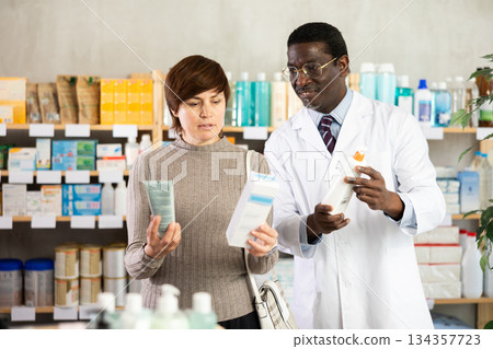 Woman choosing cream with help from pharmacist 134357723