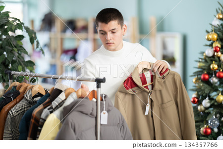 guy picks up a brown cape in the shop guy picks up a brown cape in the shop 134357766