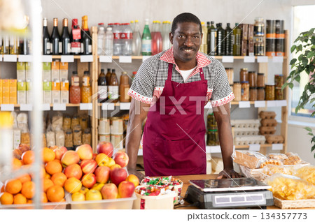 Adult man seller at counter in grocery store 134357773