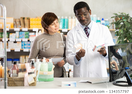 Male pharmacist offers woman prescription pills Male pharmacist offers woman prescription pills 134357797