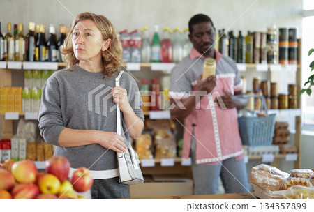 Adult woman choosing food in grocery store Adult woman choosing food in grocery store 134357899
