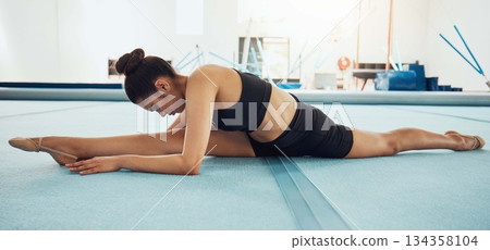 Woman stretching legs for fitness workout at gym, doing cardio training at an arena and energy for sports exercise at sport club. Girl gymnast or athlete doing gymnastics for wellness and health 134358104