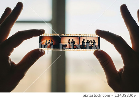 Hands Holding Filmstrip Memories Against Window Light 134358309