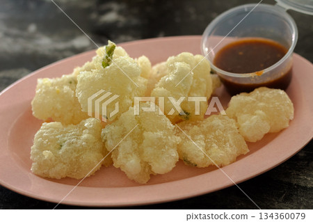 Close-up of Indonesian Traditional Snack Cireng (Fried Tapioca Starch) with Puffy Texture and Savory Flavor, Paired with Sweet Spicy Dip. Close-up of Indonesian Traditional Snack Cireng (Fried Tapioca Starch) with Puffy Texture and Savory Flavor, Paired with Sweet Spicy Dip. 134360079
