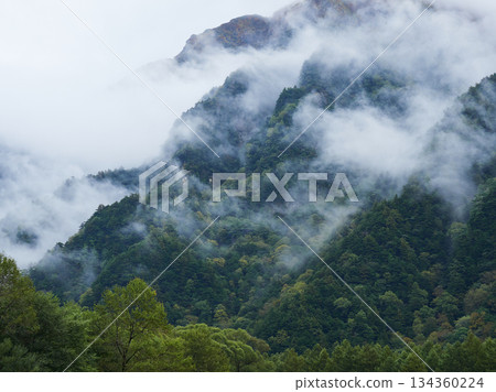 秋季旅遊景點上高地森林和穗高山脈的霧氣繚繞的景色 秋季旅遊景點上高地森林和穗高山脈的霧氣繚繞的景色 134360224