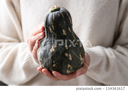 Green butternut squash pumpkin holding by woman hand 134361617